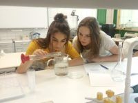 Zdjęcie przedstawiające uczennice w trakcie zajęć w laboratorium
